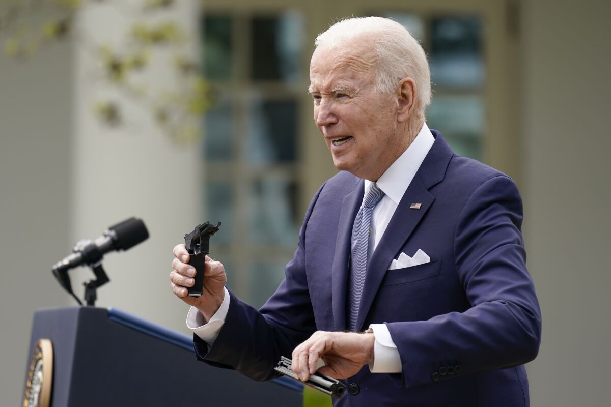 President Biden holds pieces of a pistol as he speaks about his  ghost-gun rule 