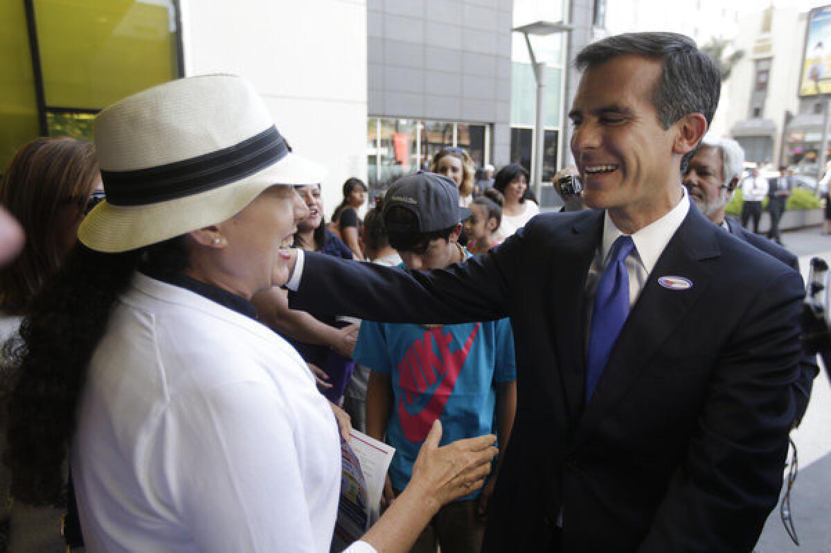 Los Angeles mayoral candidate Eric Garcetti greets riders at a Metro stop.