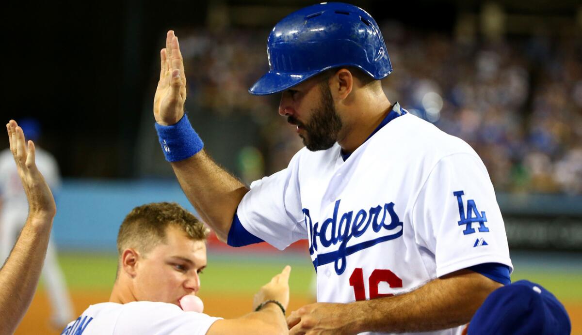 Dodgers right fielder Andre Ethier is congratulated by teammates after scoring a run in the seventh inning against the Cubs on Saturday night.