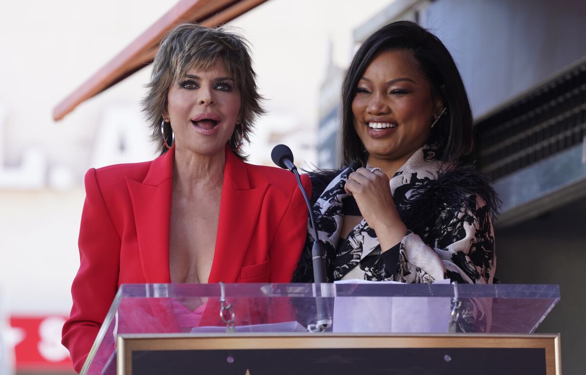 Two women stand at a podium, laughing
