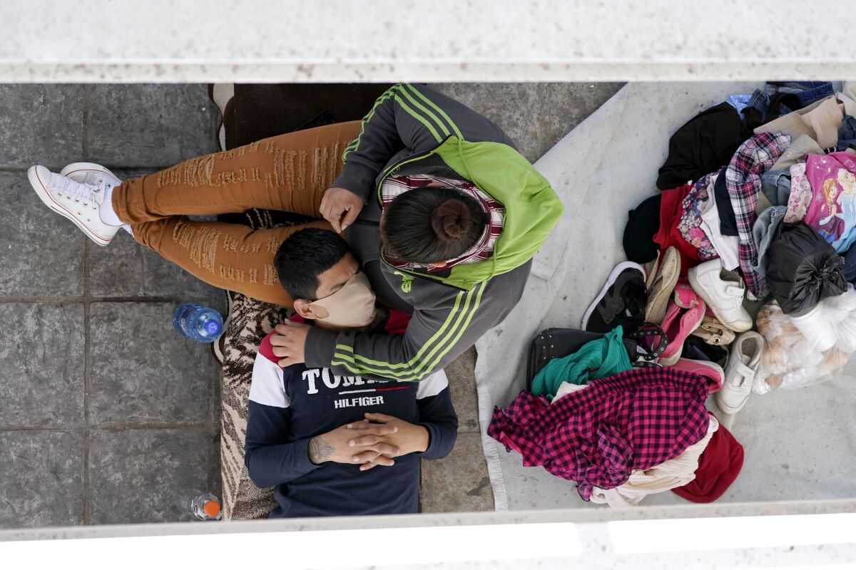 Migrants resting under a bridge ramp