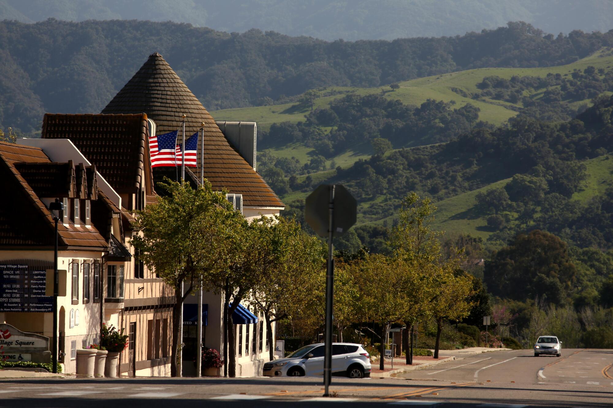 A lone car drives down a deserted Alisal Road in downtown Solvang.