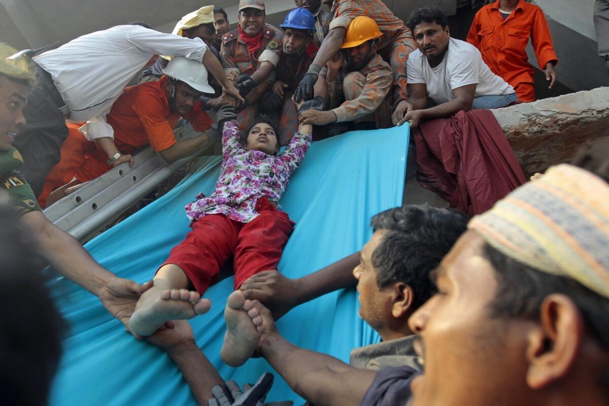 Rescuers lower a survivor from debris of a building that collapsed in Bangladesh.