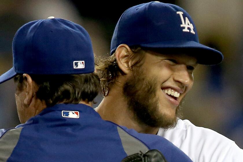 Dodgers starter Clayton Kershaw, right, is congratulated by pitching coach Rick Honeycutt after throwing a complete game against the San Diego Padres in July. Kershaw led the majors with six shutouts this season.