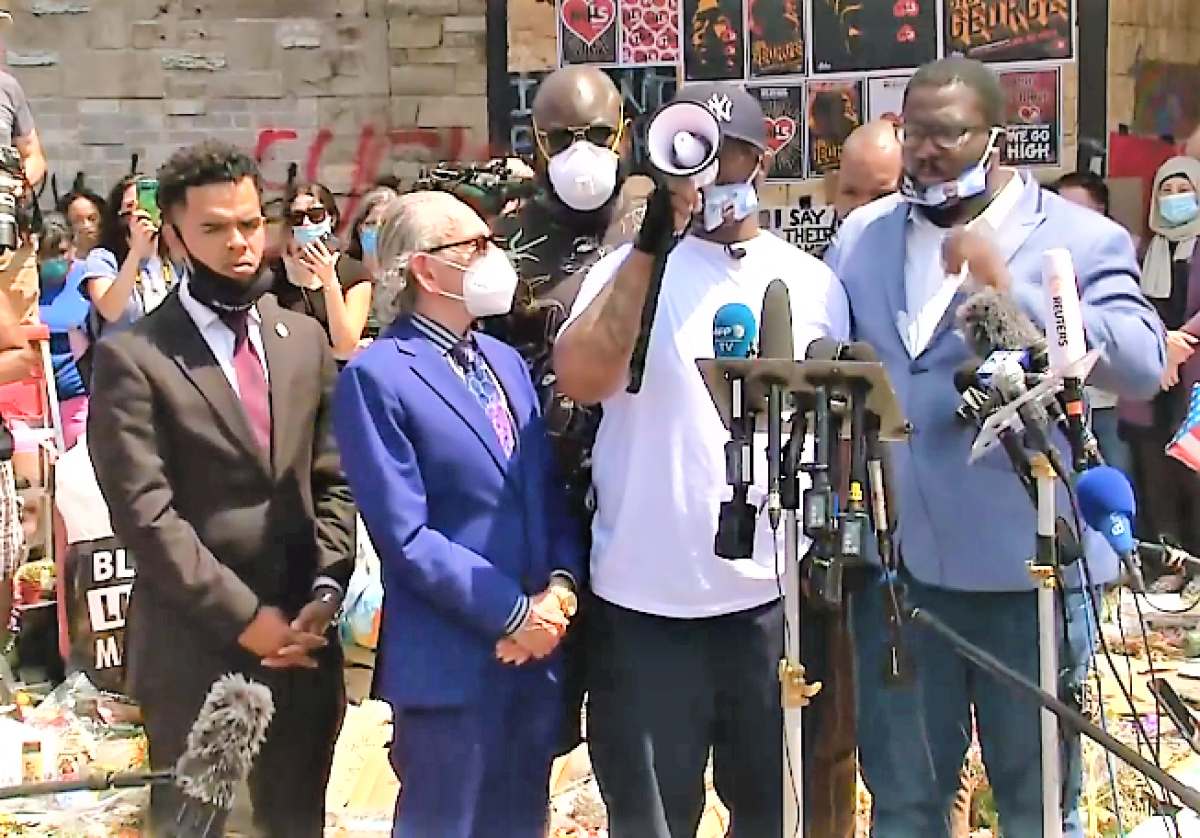 At the makeshift memorial in Minneapolis for his brother George Floyd, Terrence Floyd gives an impassioned speach to protestors urging peace. Rev. Shane Harris, of San Diego, stands on the far left.
