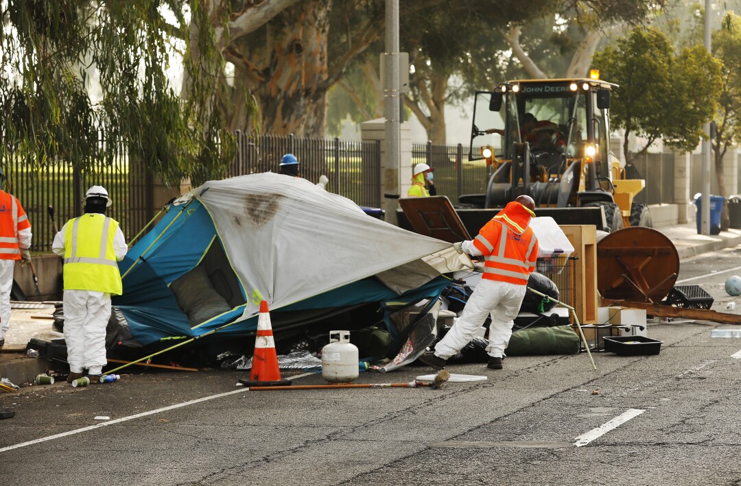 Members of a cleanup team are dismantling tents at Veterans Row's homeless camp.