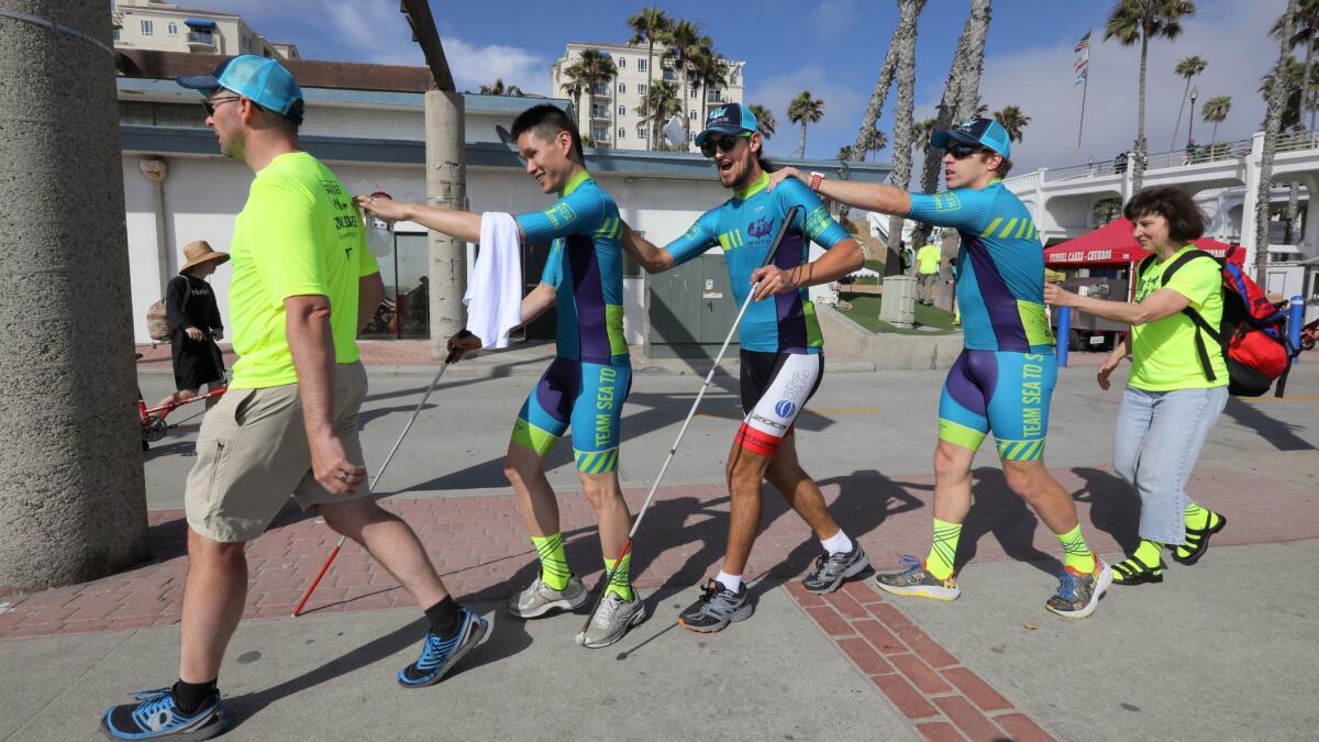 Team Sea to See support crew member Jim Holden, far left, leads blind team members to the Race Across America office near Oceanside Pier. They are Jack Chen, second from left, alternate rider Mark Woodard, Kyle Coon, and Tina Ament.