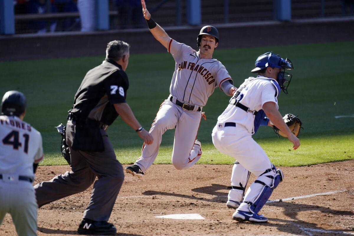 San Francisco's Mike Yastrzemski, second from right, scores past Dodgers catcher Will Smith.