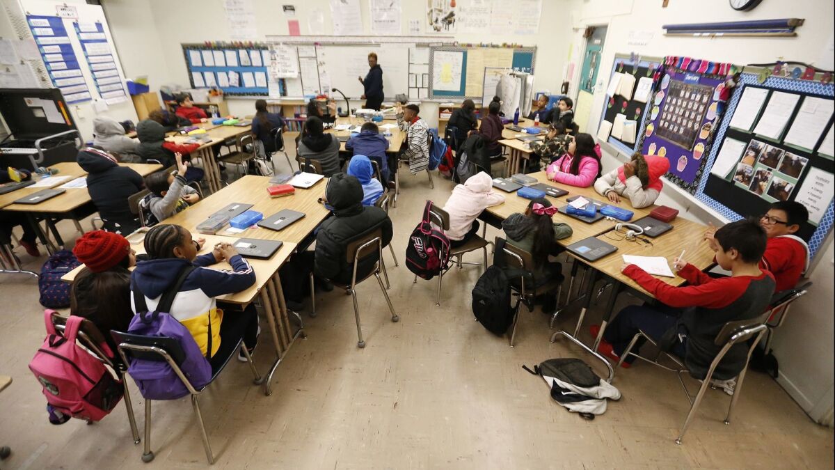 Fifth grade students listen to instructor Yoland Jordan in a classroom at 99th Street Elementary school in South Los Angeles on Jan. 17.