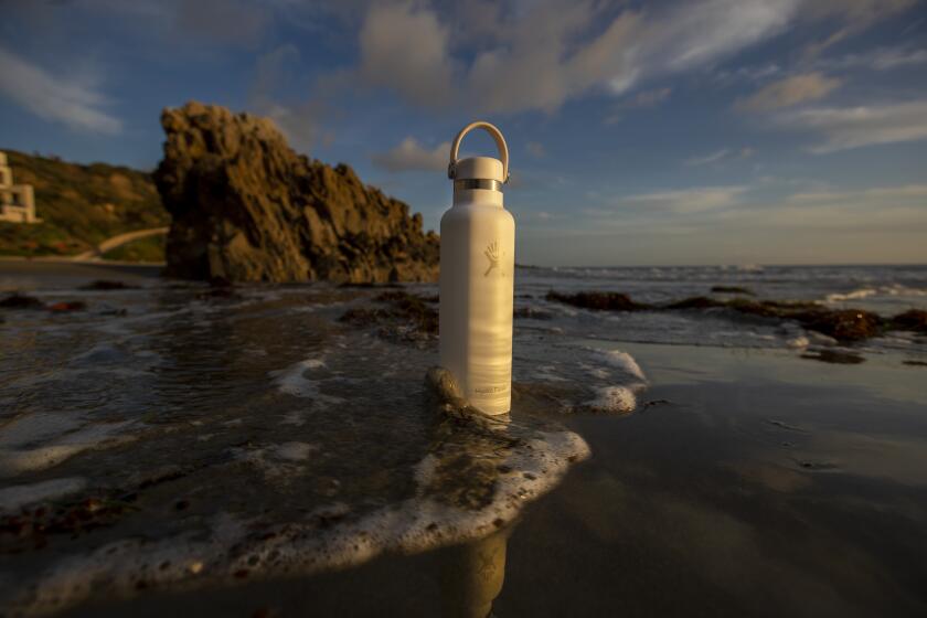 CORONA DEL MAR, CALIF. -- WEDNESDAY, JANUARY 8, 2020: Ella-Lin Espinosa, 11, of Newport Beach, and her Hydro Flask, are photographed at Corona del Mar State Beach in Newport Beach, Calif., on Jan. 8, 2020. Hydro Flask, an insulated water bottle, has become a must-have accessory for tweens and teens. Teens like its sleek and customizable look, its durability and the notion that they're helping protect the planet from environmental harm, and it has become a staple of the "VSCO girl" aesthetic. The product was launched by an outdoorsy couple, but now it's run by a $4-billion company whose other brands include OXO, which makes the most mainstream of kitchen tools. (Allen J. Schaben / Los Angeles Times)