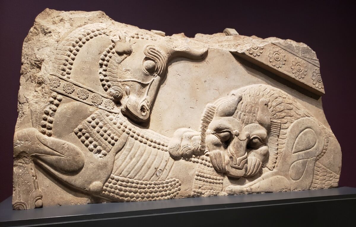 An ancient carved stone relief of a bull and a lion