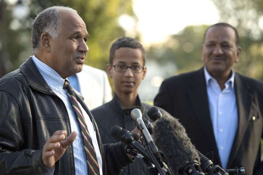 Ahmed Mohamed, center, listens with his uncle, Aldean Mohamed, right, as his father Mohamed Elhassan Mohamed speaks during a news conference in Washington, D.C. in October.