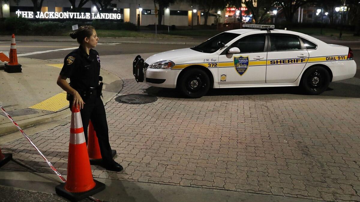 A Jacksonville, Fla., sheriff's deputy guards the perimeter of the Jacksonville Landing complex on Monday after the mass shooting at a "Madden NFL" tournament the day before.