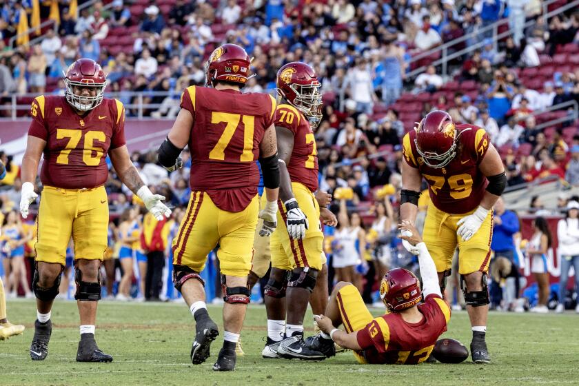 USC offensive lineman Jonah Monheim helps quarterback Caleb Williams after he was sacked 