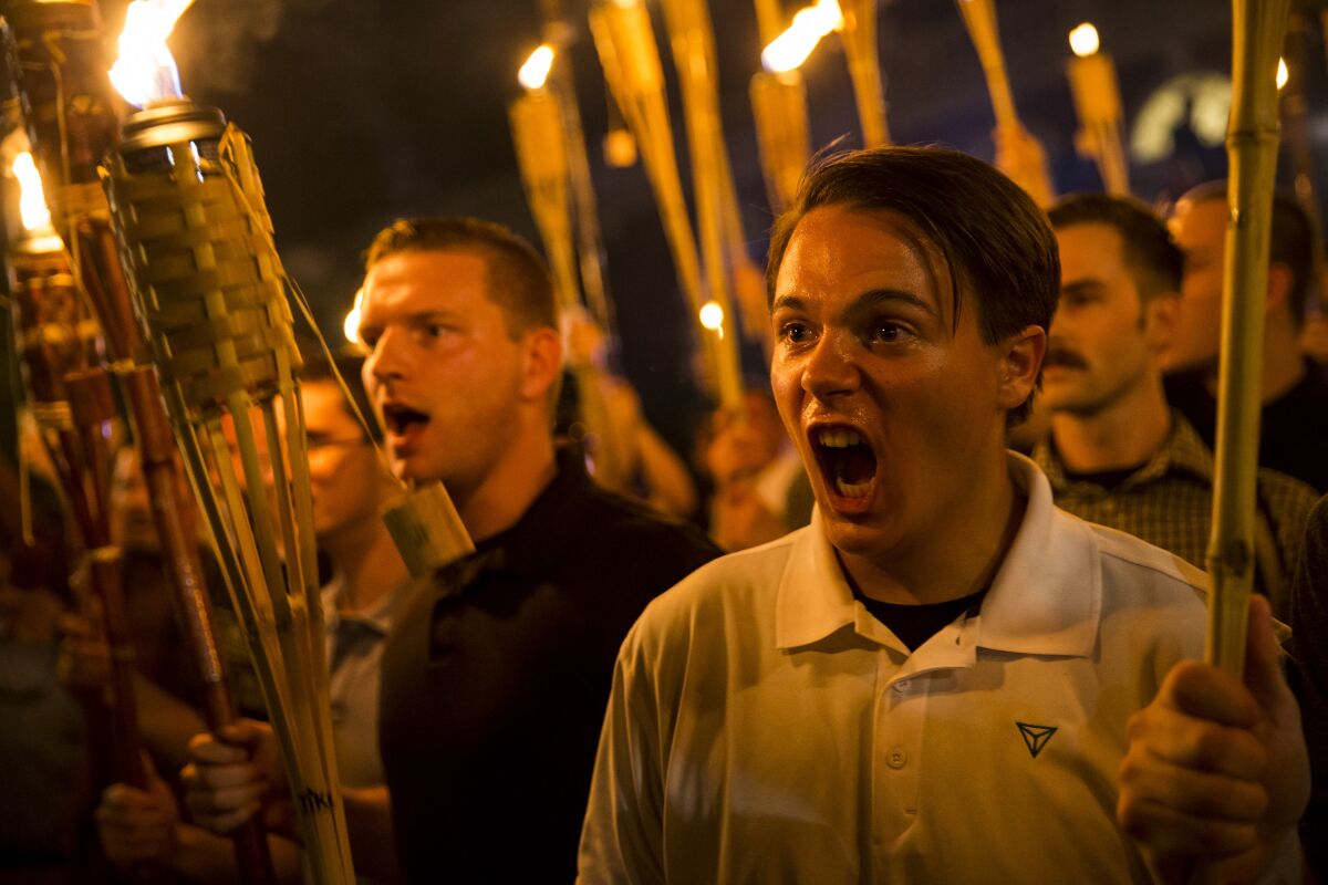 Two men shouting and holding tiki torches. 