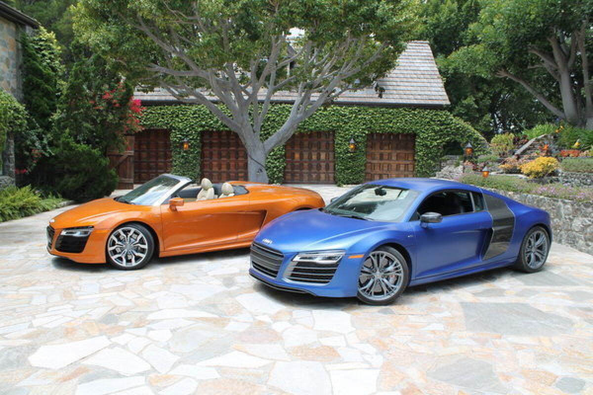 Two versions of Audi's refreshed 2014 R8 lineup on display. At left is the 430-horsepower V8 Spyder, while at right is the 550-horsepower V10 Plus model.