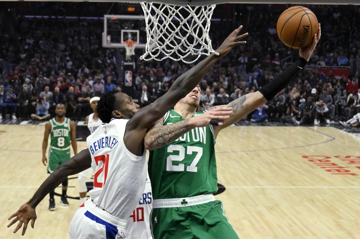 Clippers guard Patrick Beverley defends on a shot by Boston Celtics forward Daniel Theis on Nov. 20 at Staples Center.