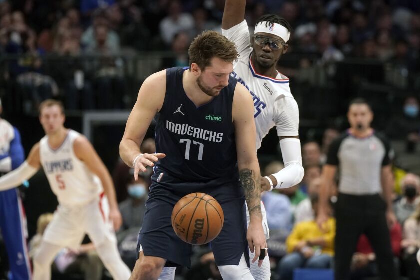 Dallas Mavericks guard Luka Doncic (77) keeps the ball from Los Angeles Clippers guard Reggie Jackson (1) during the first quarter of an NBA basketball game in Dallas, Thursday, Feb. 10, 2022. (AP Photo/LM Otero)