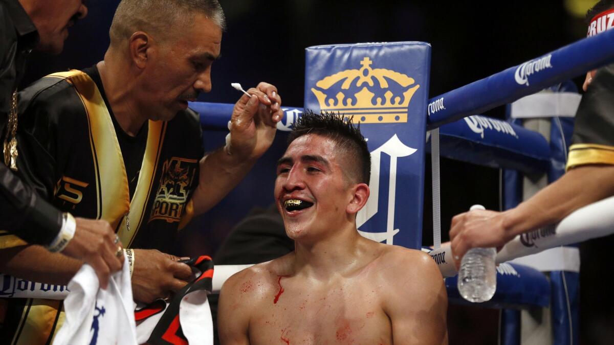 A bloodied but smiling Leo Santa Cruz sits in his corner between rounds before eventually beating Kiko Martinez by TKO during their World Featherweight Championship bout at the Honda Centerin Anaheim.