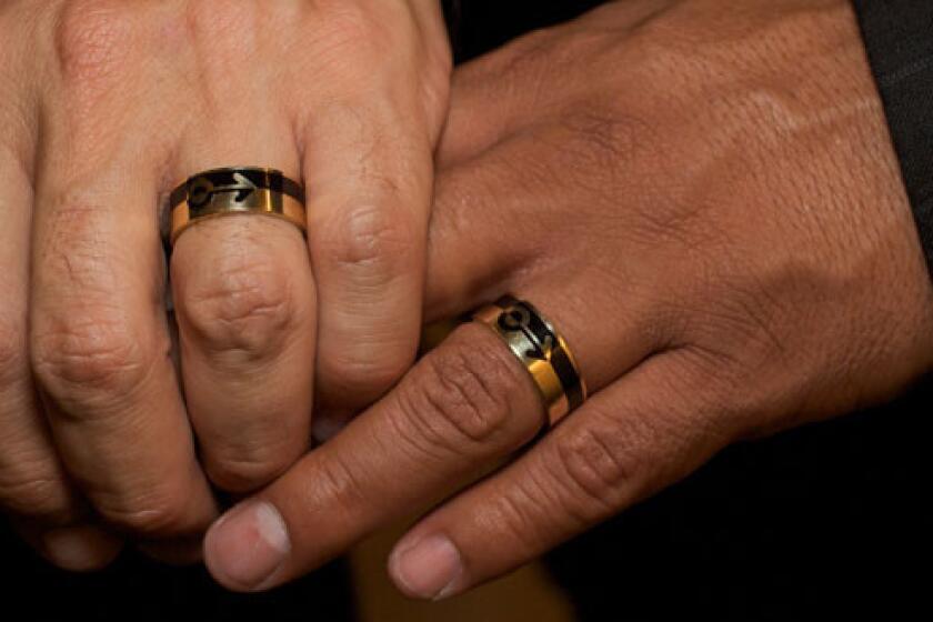 A same-sex couple hold hands as they get married in Los Angeles in 2008. Recently, Wyoming legislators have moved toward reaching a consensus on broadening domestic partnerships.