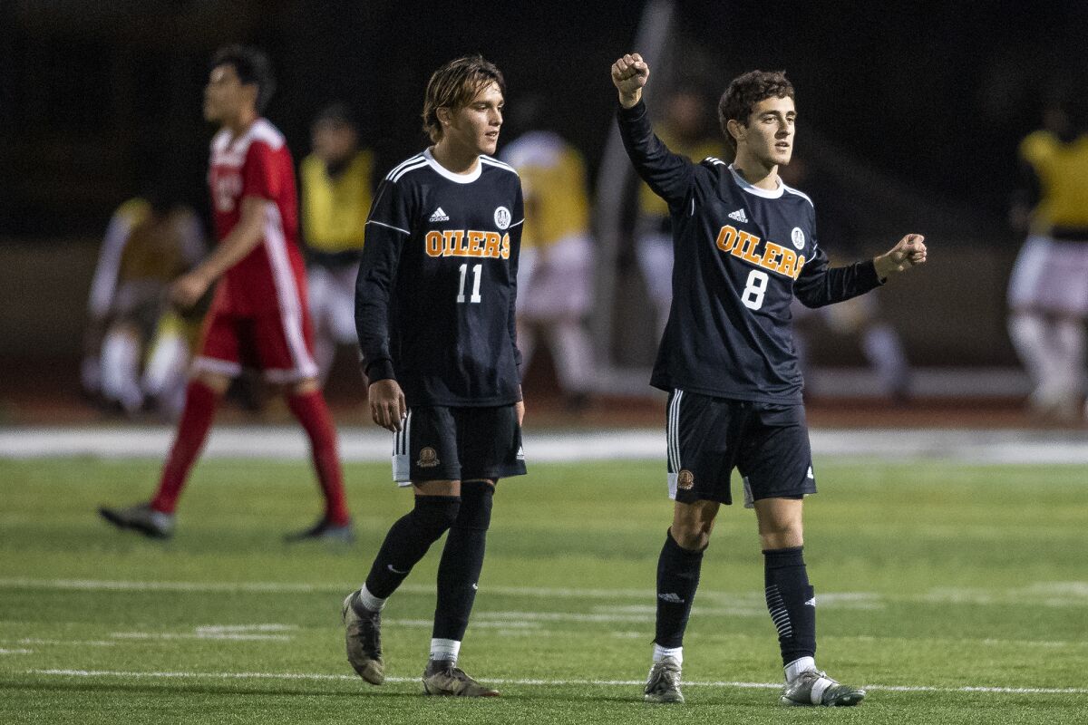 Huntington Beach's Kalani Delarole, left, and Steven Venetantis celebrate a win over Santa Ana in the All-Turf Tournament.