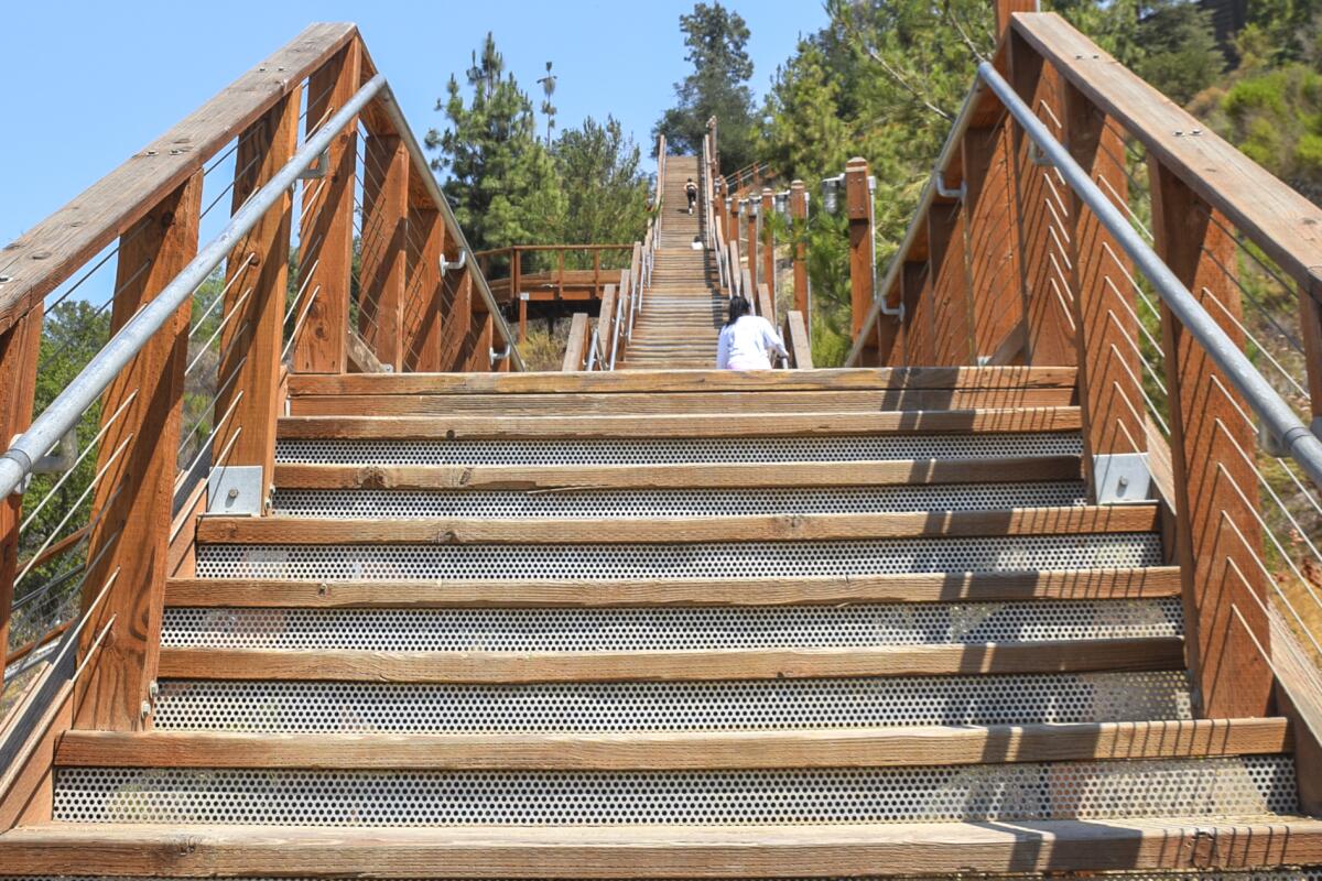 People walk the one of the staircases of Hillcrest Stairs in July 2022 in Fullerton, CA.
