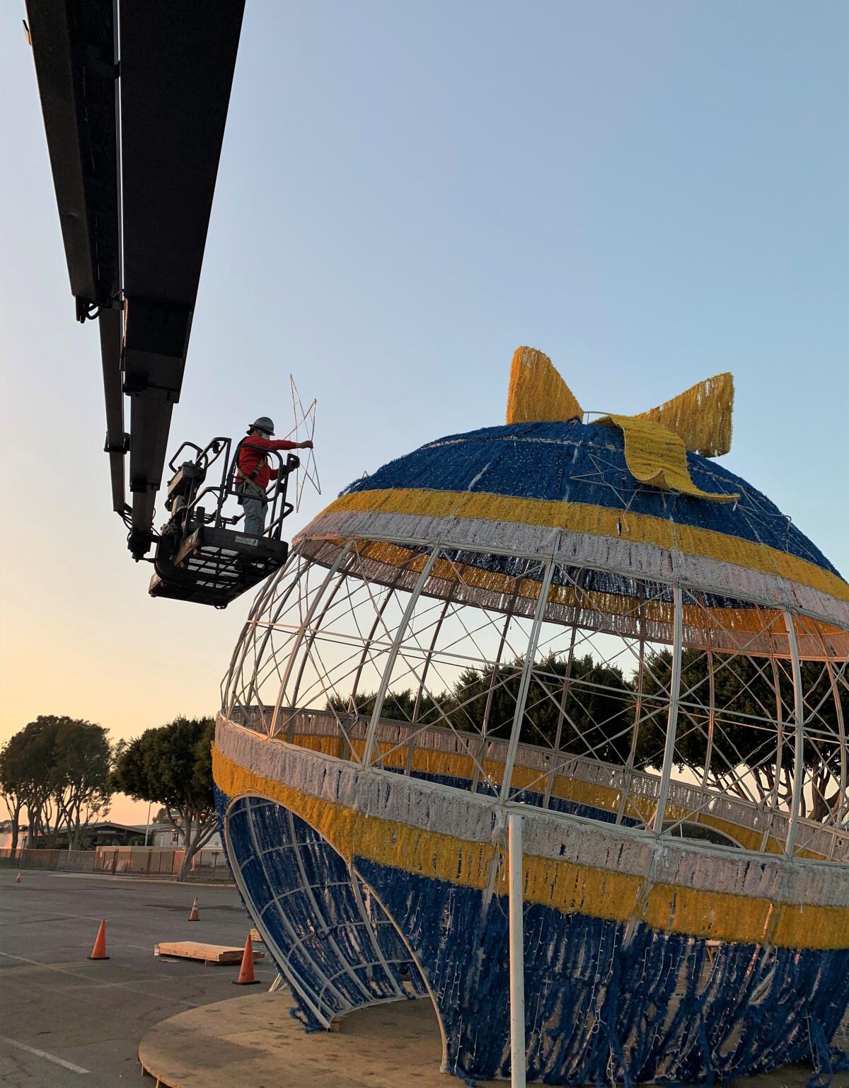 Workers put the finishing touches on a giant ornament for "Night of Lights OC."