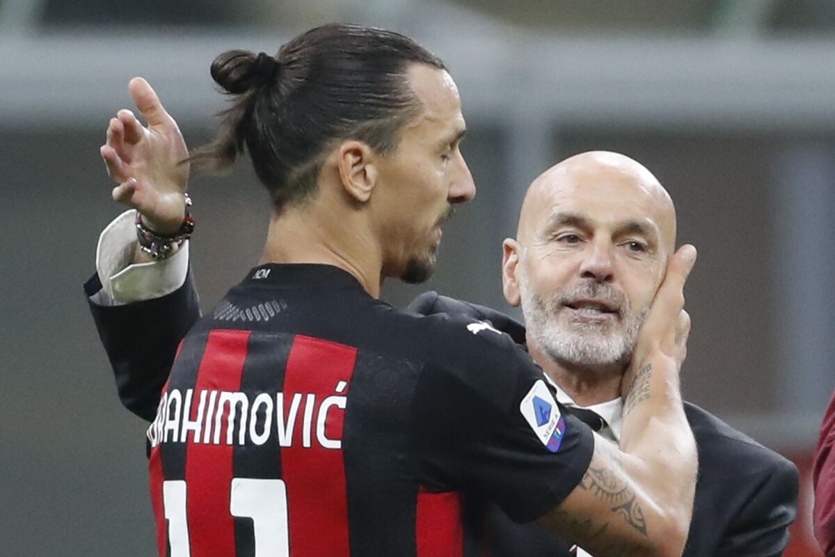 FILE - In this Saturday, Oc.t 17, 2020 file photo, AC Milan manager Stefano Pioli, right, congratulates Zlatan Ibrahimovic at the end of the Serie A soccer match between Inter Milan and AC Milan at the San Siro Stadium, in Milan, Italy. AC Milan coach Stefano Pioli has recovered from the coronavirus and will be back on the sidelines for Thursday’s Europa League match against Celtic. Milan said on Wednesday that the latest tests carried out on Pioli and his assistant Giacomo Murelli were negative for COVID-19. (AP Photo/Antonio Calanni, File)