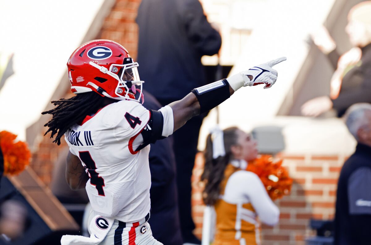 Georgia running back James Cook (4) points to fans as he scores a touchdown during the first half of an NCAA college football game against Tennessee, Saturday, Nov. 13, 2021, in Knoxville, Tenn. (AP Photo/Wade Payne)