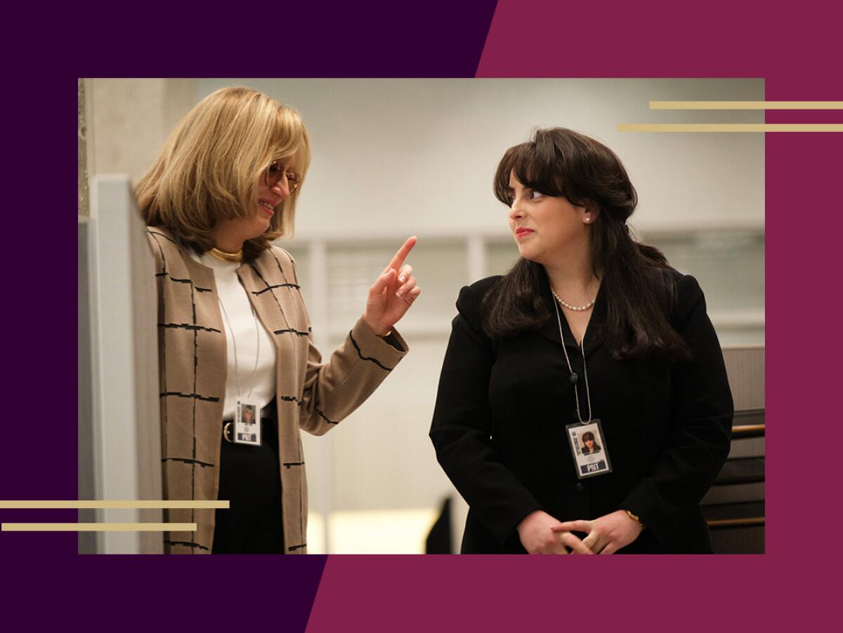 Two women in business attire talk to one another