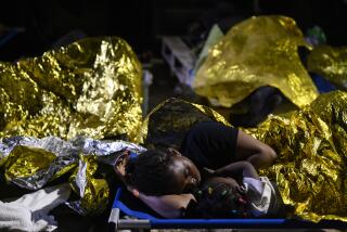 A woman and a child sleep outside the Lampedusa's migrant reception center, Sicily, early Thursday Sept. 14, 2023. The reception center in Italy's southernmost island of Lampedusa remained critical Thursday as it coped with transferring to the mainland thousands of migrants who arrived on small, unseaworthy boats in a 24-hour span this week. (AP Photo/Valeria Ferraro)