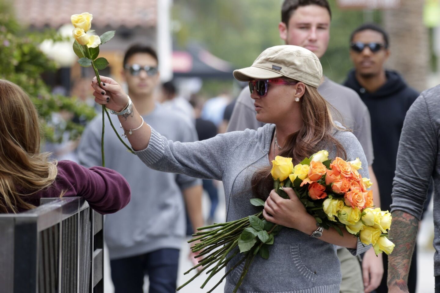 Caitlyn Dixon distributes roses in Isla Vista on May 24, the day after a shooting rampage left six people and the gunman dead.
