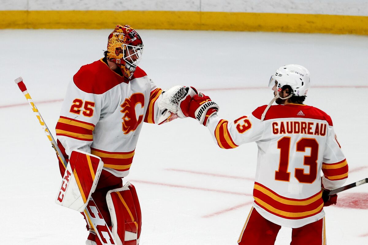 Calgary Flames goalie Jacob Markstrom (25) is congratulated on his win over the Los Angeles Kings by forward Johnny Gaudreau (13) following an NHL hockey game Monday, April 4, 2022, in Los Angeles. The Flames won 3-2. (AP Photo/Ringo H.W. Chiu)