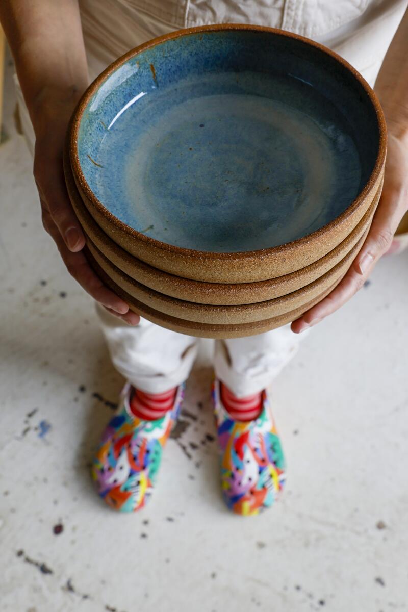 Potter Becki Chernoff holds ceramic bowls 