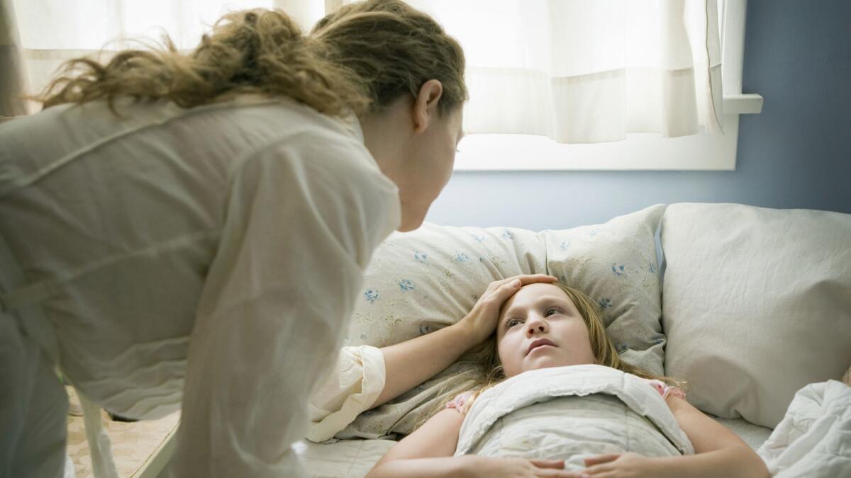 A mother comforts a sick child in a Chicago hospital room. Will a government healthcare program be there to help?