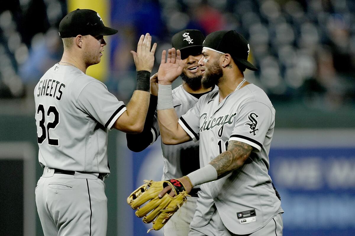 Chicago White Sox's Gavin Sheets (32), Lenyn Sosa, center and Yoan Moncada, right, celebrate after the second game of a baseball doubleheader against the Kansas City Royals Tuesday, Aug. 9, 2022, in Kansas City, Mo. The White Sox won 3-2. (AP Photo/Charlie Riedel)