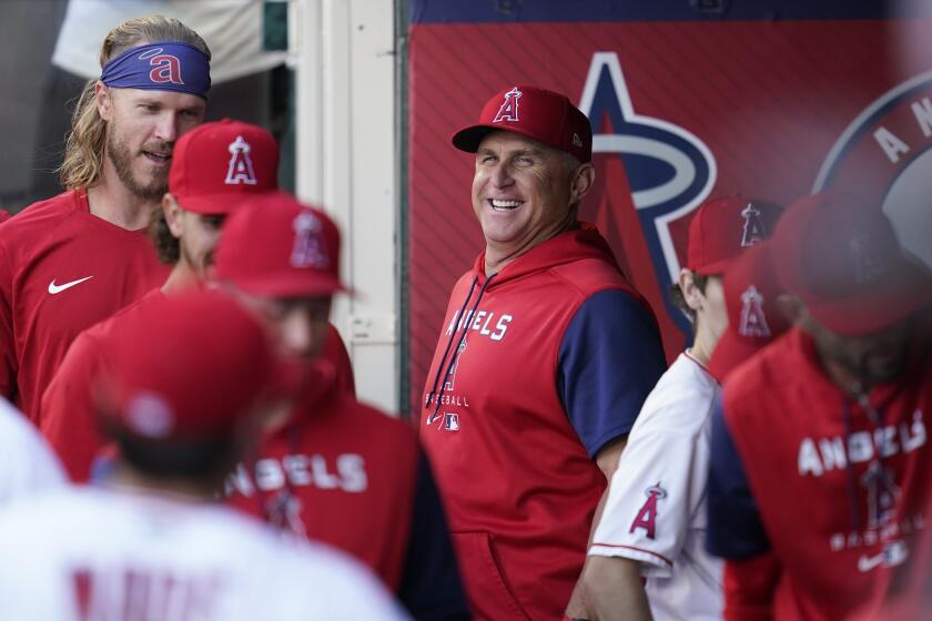 Angels interim manager Phil Nevin, center, smiles in the dugout before a game against the Boston Red Sox on June 7, 2022.