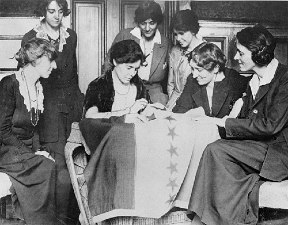Celebrating ratification of the woman's suffrage amendment, Alice Paul sews a 36th star on a banner in August 1920.