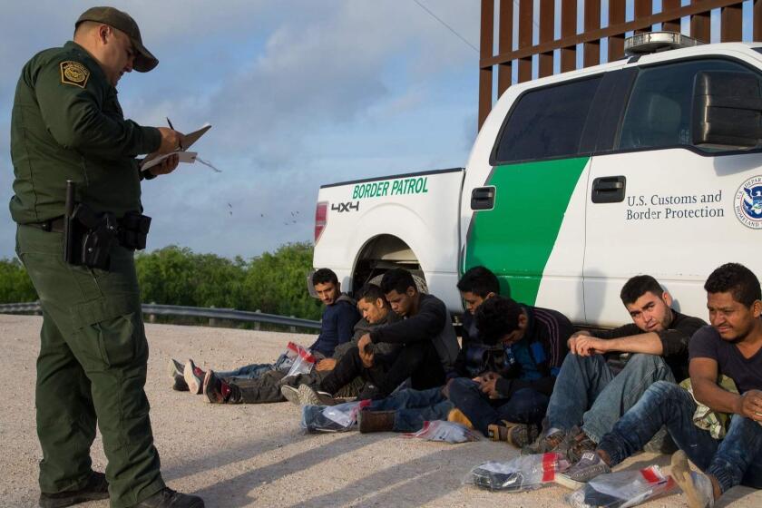 (FILES) In this file photo taken on March 26, 2018 a Border Patrol agent apprehends illegal immigrants shortly after they crossed the border from Mexico into the United States in the Rio Grande Valley Sector near McAllen, Texas. - A Philadelphia judge receives an email to inform him that the case of an undocumented young man he was carrying had been reassigned to another court to finally close it and order his deportation. The decision, made by the Department of Justice (DoJ), is part of a policy of greater pressure for the immigration judges of the United States to decide on the processes under their charge more quickly. Immigration justice in the United States does not depend on the Judicial Power, but on the Executive. They are administrative courts and the judges are appointed by the attorney general, who is the head of the DoJ. (Photo by Loren ELLIOTT / AFP)LOREN ELLIOTT/AFP/Getty Images ** OUTS - ELSENT, FPG, CM - OUTS * NM, PH, VA if sourced by CT, LA or MoD **