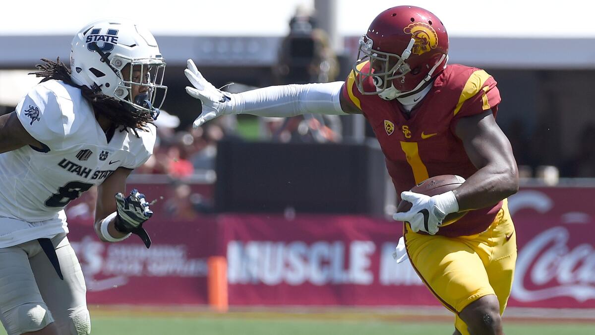 USC receiver Darreus Rogers picks up yards against Utah State defensive back Welsey Bailey during the game Saturday.
