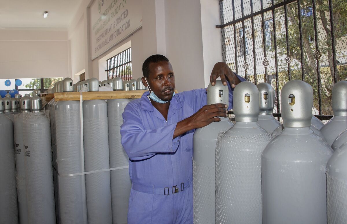 A worker shows oxygen cylinders during an event to unveil a new oxygen plant at Banadir hospital in Mogadishu, Somalia Thursday, Sept. 30, 2021. Somalia has opened the country's first public oxygen plant as the Horn of Africa nation with one of the world's weakest health systems combats COVID-19. (AP Photo/Farah Abdi Warsameh)