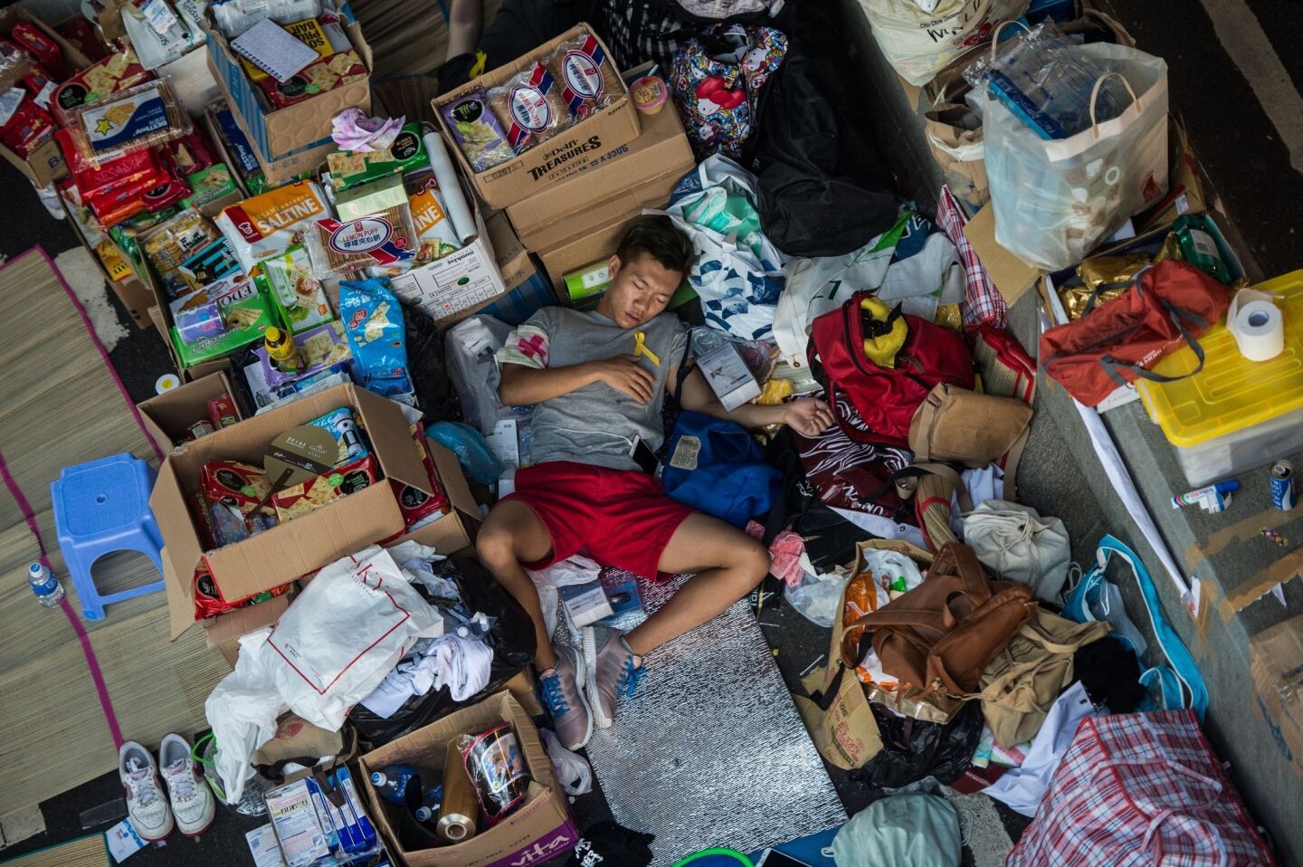 A protester working as a medical volunteer sleeps in a makeshift supplies area on an overpass in Hong Kong.