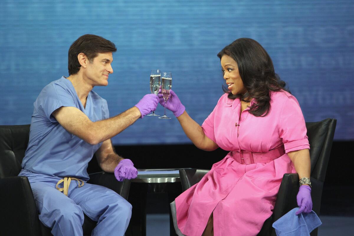 Toasting their profits from fooling the American public? Dr. Oz (left) and his prime enabler, Oprah Winfrey.