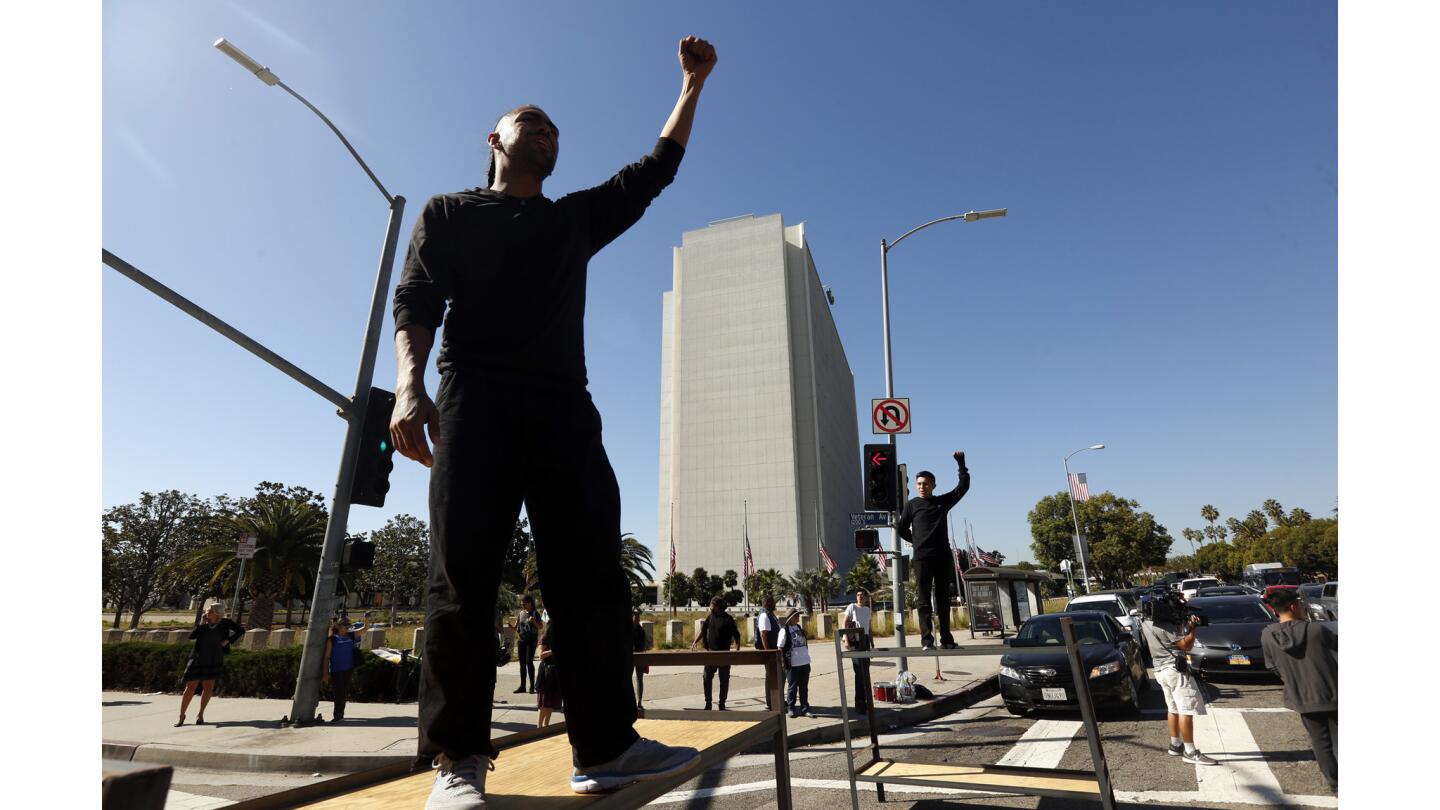Immigrant rights activists, some standing on bunk-bed frames, block traffic in Westwood as part of demonstrations coinciding with the Oct. 5 deadline for Deferred Action for Childhood Arrivals recipients to renew their permits.