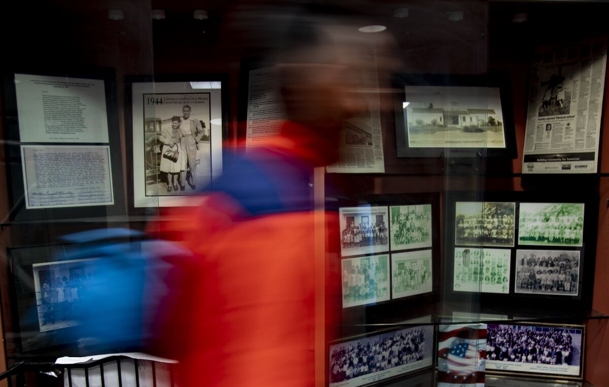 A student walks by a display case with historic photos at Mendez Fundamental Intermediate School. 