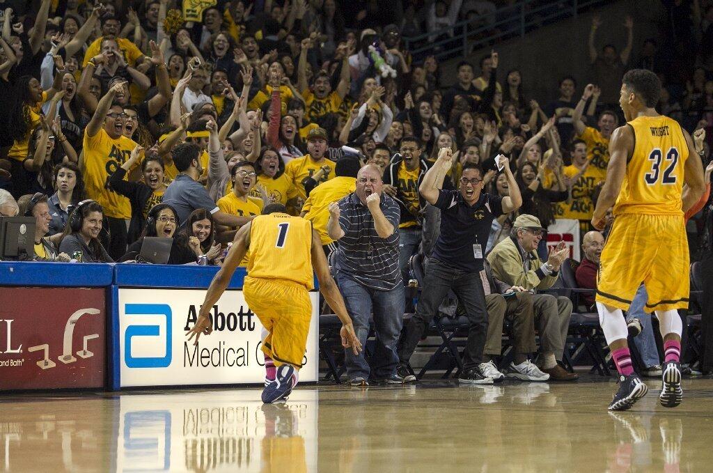 UC Irvine's Alex Young, left, celebrates a half court shot at the buzzer in the first half during a game against Hawaii on Saturday.