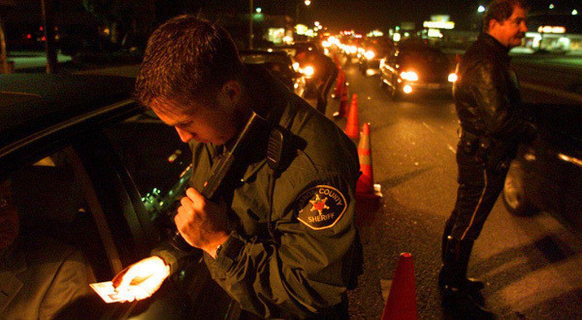 Orange County sheriff's Deputy Jeff Puckett checks a motorist's identification at a DUI checkpoint.