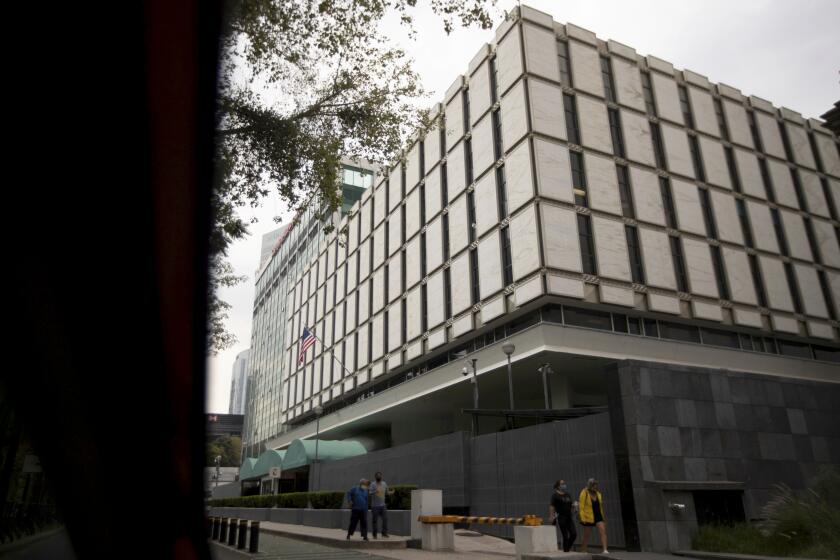 Pedestrians walk past the U.S. Embassy in Mexico City, Thursday, Oct. 29, 2020. Federal prosecutors say Brian Jeffrey Raymond, a former U.S. embassy worker in Mexico City, is believed to have drugged and sexually assaulted as many as two dozen women. He was arrested earlier this month in San Diego. Raymond has been charged in one case involving a woman who was found naked and screaming from the balcony of an embassy-leased apartment in Mexico City. (AP Photo/Fernando Llano)