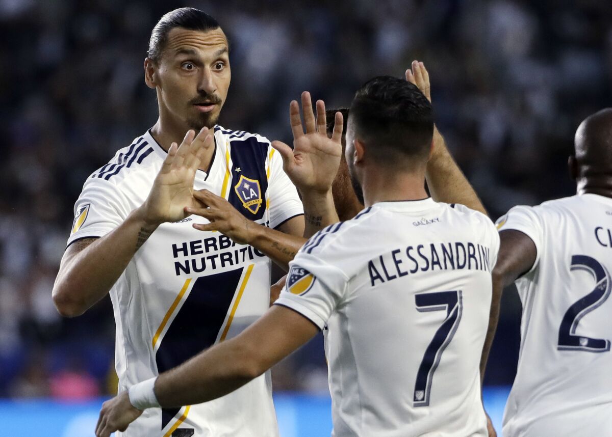 Galaxy forward Zlatan Ibrahimovic, being congratulated by midfielder Romain Alessandrini during a previous game, had a hat trick Sunday night.