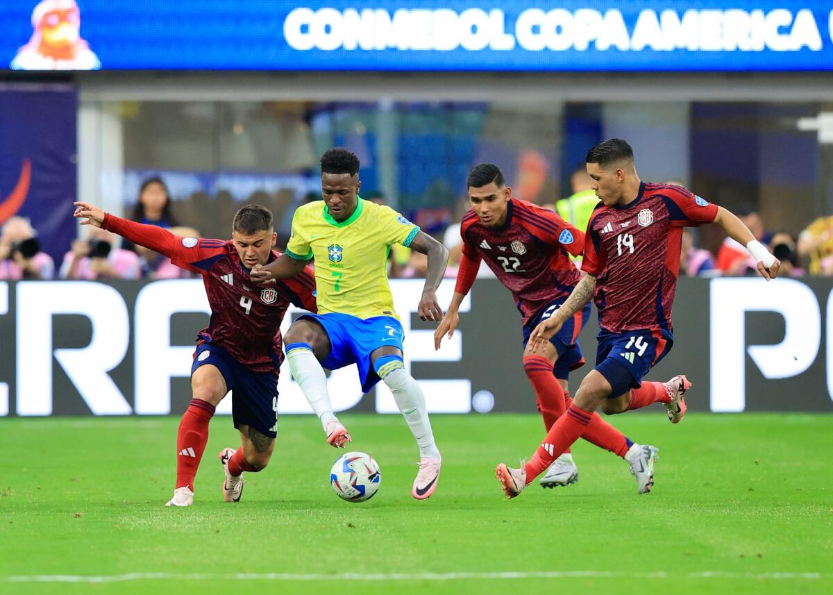 Vinicius Junior es seguido por tres jugadores ticos durante el partido entre Costa Rica y Brasil.